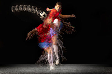 Obraz premium Non stop moving. Young caucasian football soccer player playing in motion in mixed light on dark background.
