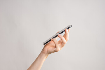 Slim modern smartphone in a woman's hand, use the Internet or apps on your phone.