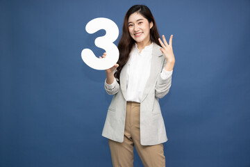 Young beautiful Asian woman showing number 3 and pointing up with finger number three isolated on...
