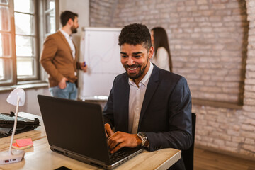 Fototapeta premium African american businessman with laptop in open space office.