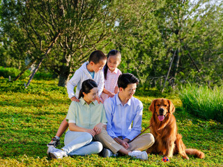 Happy family of four and pet dog in the park