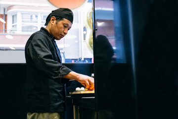 Asian chef preparing nigiris sushi