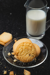 Closeup 'Cookies and milk are placed on a black background.