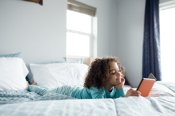 Smiling girl reading digital book