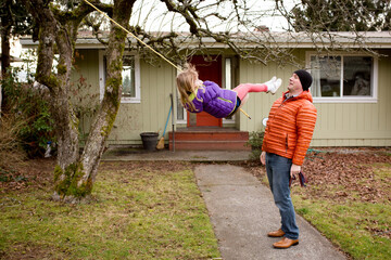 Girl on swing almost kicks father