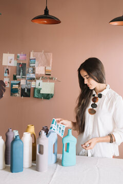Young Woman Comparing a Colored Plastic to Pantone Palette