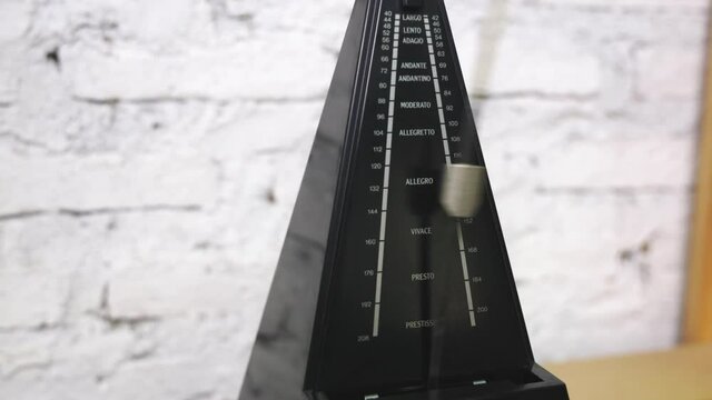 Antique metronome with pendulum in slow motion. Vintage wooden classic style. Equipment of music, beat, rhythm mechanism. 4K 25fps Video Footage.
