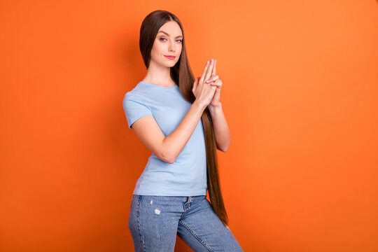 Profile photo of strict long hairdo young lady hands gun wear blue t-shirt isolated on vivid orange color background
