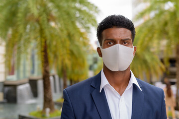 Portrait of African Portrait of African businessman wearing face mask outdoors