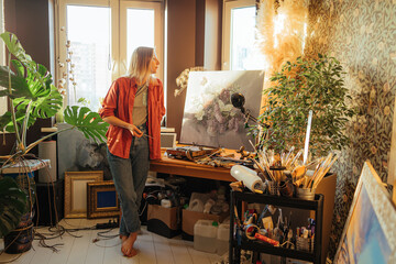 woman artist stands next to the painted picture