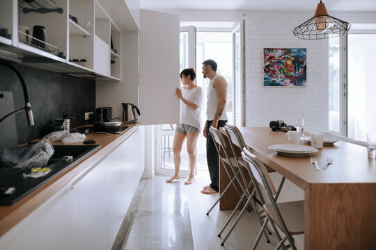 A loving couple in the kitchen. - Powered by Adobe