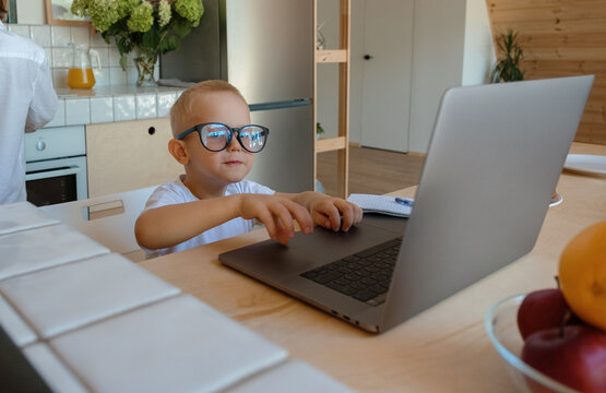 Boy in glasses using laptop for studies
