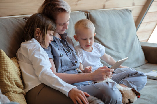 Woman and kids watching video on tablet in weekend