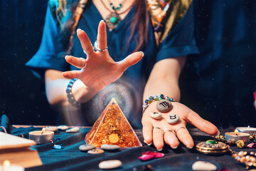 Astrology and magic. A fortune teller holds stones with the sign of the zodiac in her hands and...
