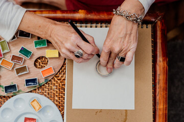 Close-up of senior woman painting mandalas with a special ruler