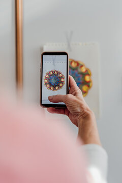senior woman taking a pic to her mandala with her phone 