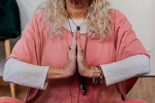 senior woman doing yoga with hands in prayer mode