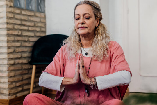 senior woman doing yoga with hands in prayer mode