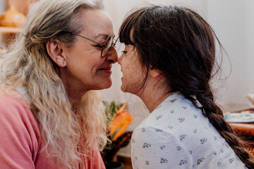 Grandmother and granddaughter looking each other with tenderness 