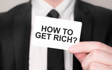 Businessman holding a card with text how to get rich