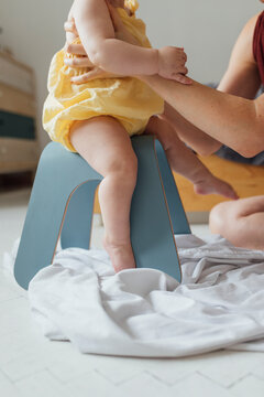 Motherhood: Child Is Learning How To Sit Properly On The Chair