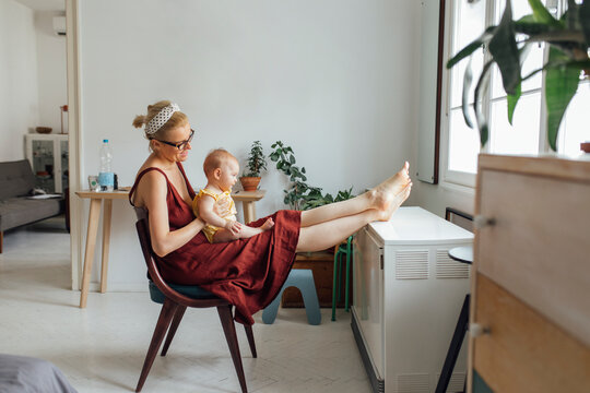 Motherhood: Blonde Woman In The Long Red Dress Holding Baby In T