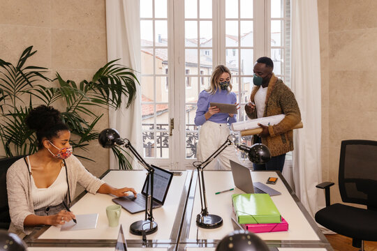 Delighted multiracial colleagues working together in office