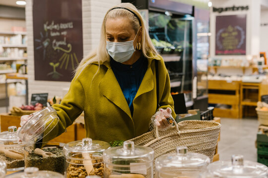 senior woman looking spices at zero waste store