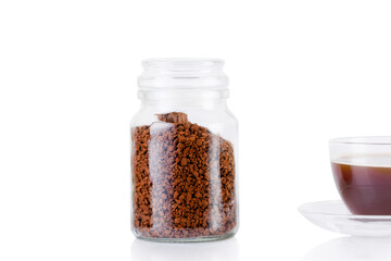 A coffee drink is poured into the cup. Delicious and aromatic coffee is poured into a cup, next to it there is a jar of coffee granules.
