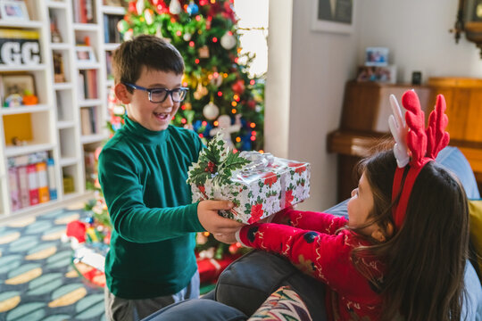 Young Boy Giving Christmas Gift to Sister 