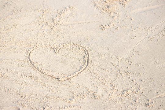 Heart shaped drawing on the beach with copy space. Valentine day and Marry Concept.