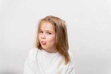 funny girl shows tongue on white background