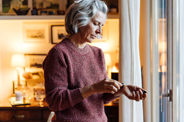Middle aged woman using essential oil on wrist