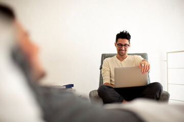 Happy man using laptop near boyfriend