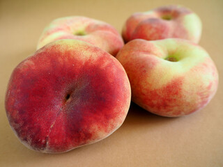 close-up of four pink peach figs lie on a brown background. side view. summer sweet fruits