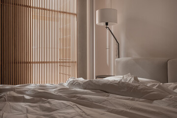 Interior of illuminated modern bedroom with light walls