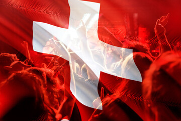 football fans supporting Switzerland - crowd celebrating in stadium with raised hands against Switzerland flag