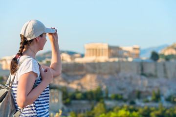 Enjoying vacation in Greece. Young traveling woman enjoying view of Athens city and Acropolis.