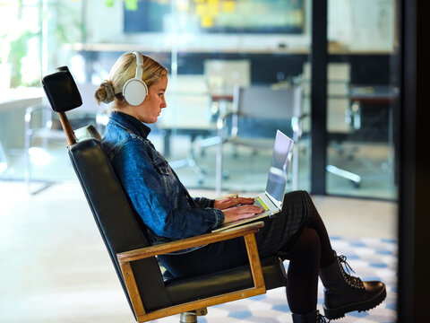 Using laptop in arm-chair.