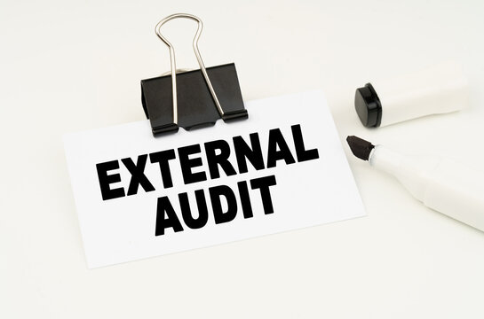 On a white background is a marker and a business card with the inscription - EXTERNAL AUDIT