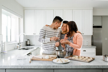 Family Happily Embraces While Cooking