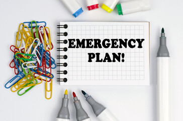 On the table are markers, paper clips and a notebook with the inscription - Emergency Plan