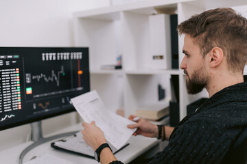 Male trader analyzing charts on computer monitor