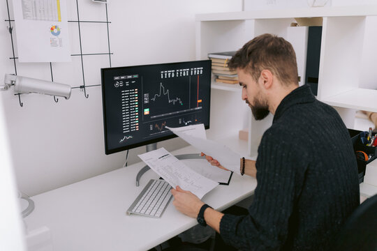 Male broker analyzing documents in office
