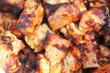 Pieces of delicious barbecued meat. Pork meat cooked on grill. Close up top view.
