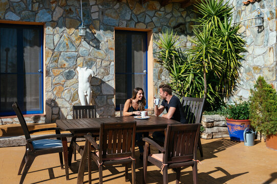 Delighted couple having breakfast on terrace