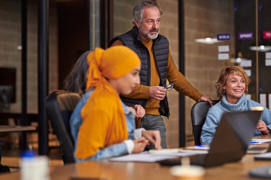 Mature man listening to colleague during meeting