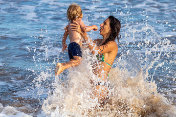 Fototapeta premium MÃE E FILHO BRINCANDO NA PRAIA.