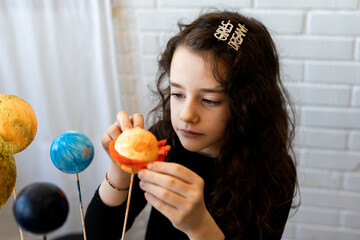 Close-up of young girl putting the ring on saturn for a science project