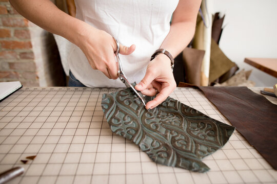 Woman trims embossed leather